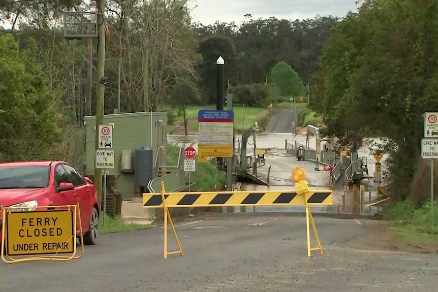 A ferry crossing over a river with a closed sign in front