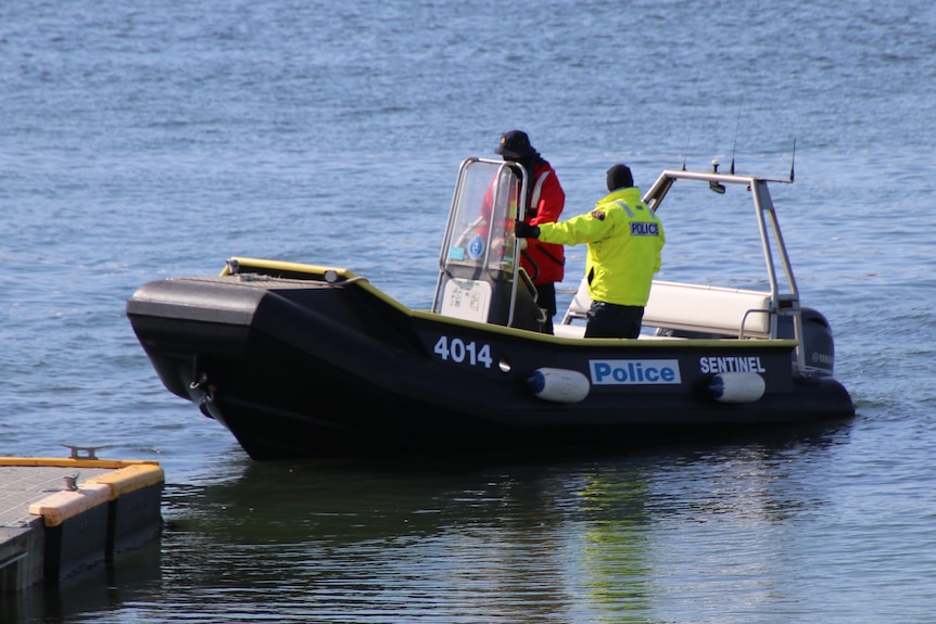 Police boat with two crew members on board.