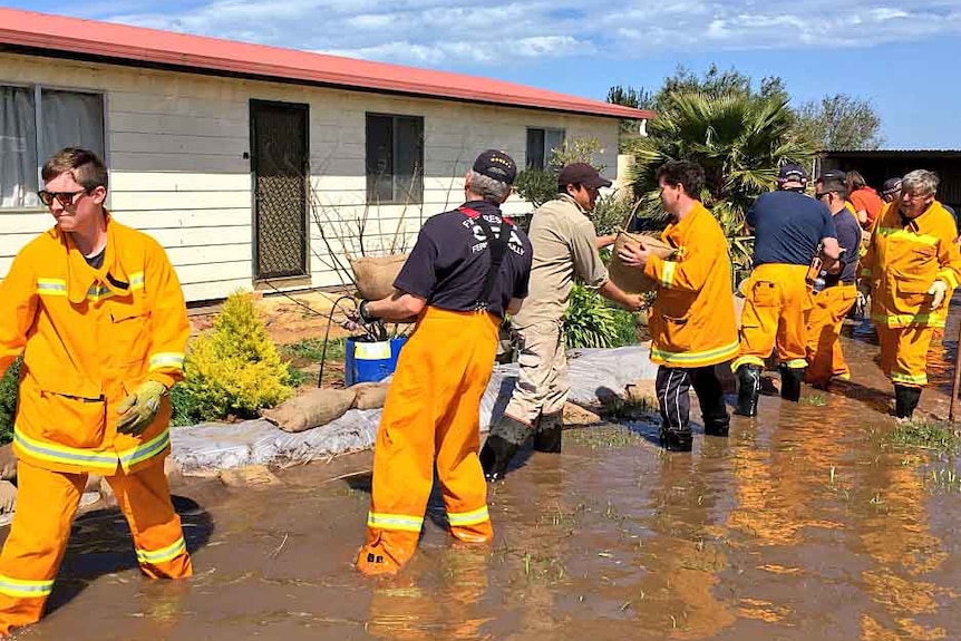 CFA volunteers sandbag a house.