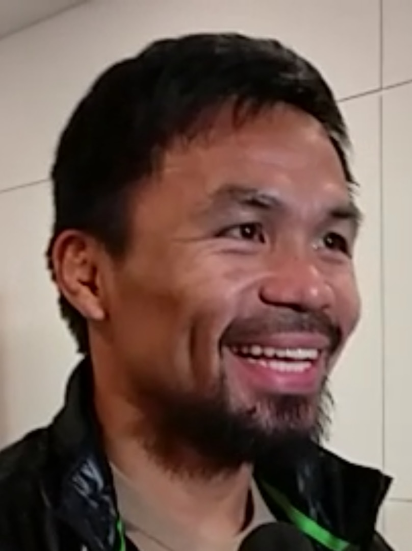 Manny Pacquiao smiles, speaks into two microphones