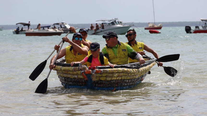 Four men and a little girl in lifeboats row in to shore on a boat made out of beer cans.