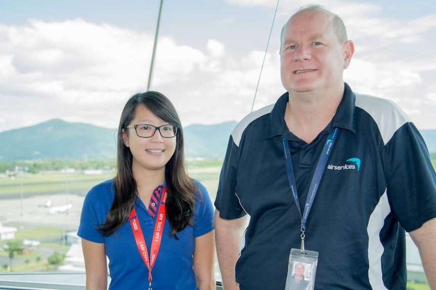 Amanda Siu and Shane Higgins stand in front of the vast windows at the Cairns Airport air traffic control tower.