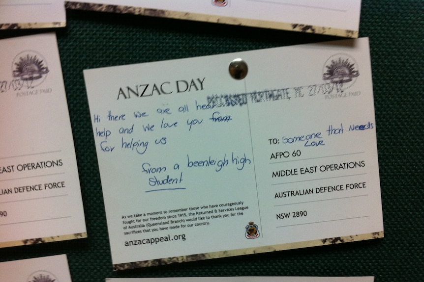 A postcard addressed to 'someone that needs love' on a pinboard at an Australian military base in Afghanistan.
