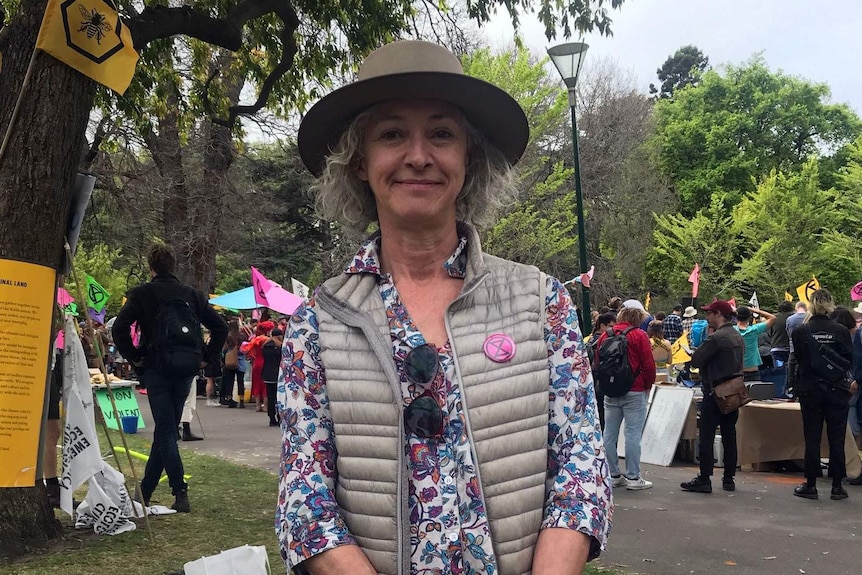 Miriam Robinson standing in Carlton Gardens near Extinction Rebellion protesters.