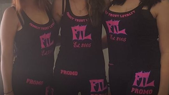 Three women showcase the clothing business logo.