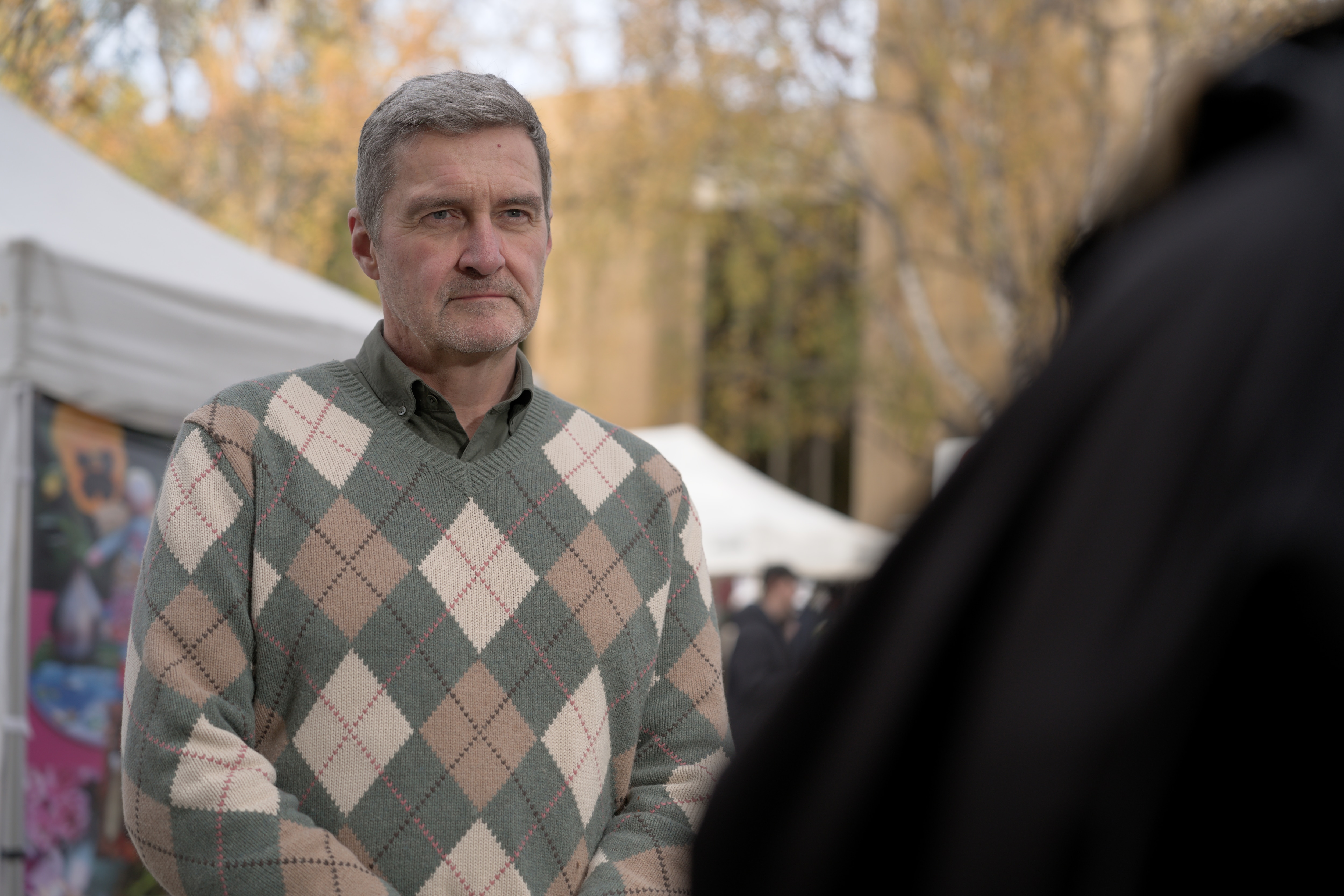 Rodney Croome standing in Salamanca Markets with marquees in the background