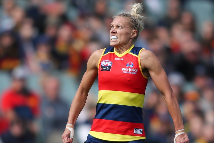 An Adelaide Crows AFLW player celebrates kicking a goal against Melbourne.