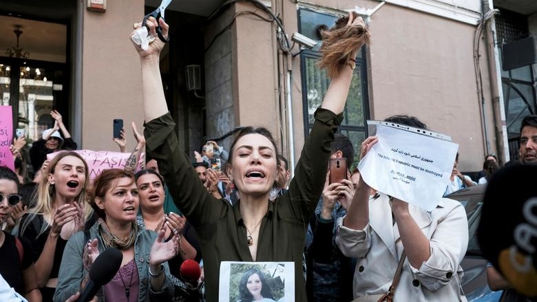 An Iranian woman living in Turkey, reacts after she cut her hair during a protest 
