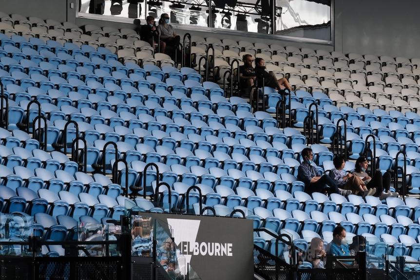 A largely empty stand at the 2022 Australian Open, with some people sitting in one corner