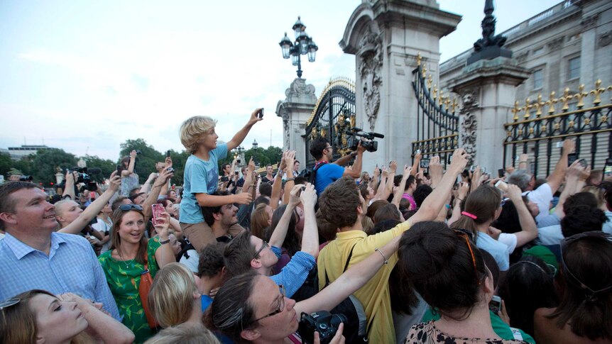 Crowds try to take photos of the notice formally announcing Royal birth.