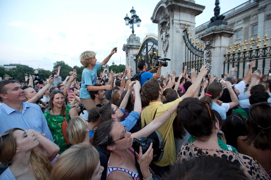 Crowds try to take photos of the notice formally announcing Royal birth.