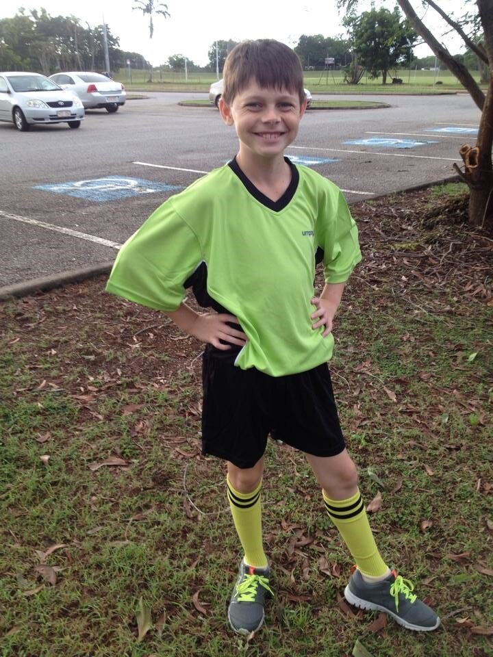 Jonty Beard wering a green umpiring shirt in a carpark.