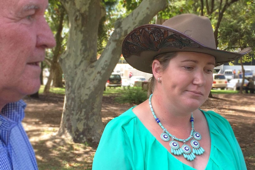 Horse breeder Amanda Nicholson, looks forlornly at the ground, flanked by Independent candidate Tony Windsor