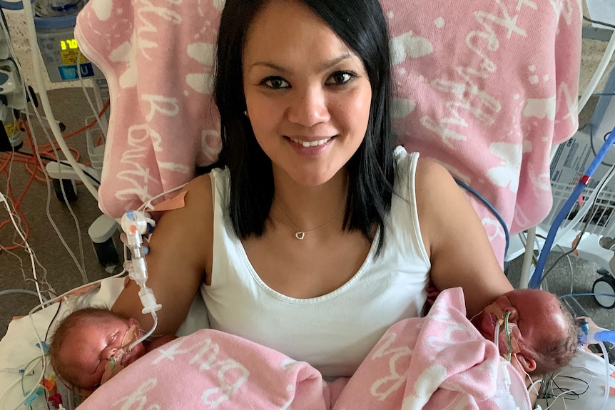 Bianca Keenan holding her two infant daughters Lia and Andie.