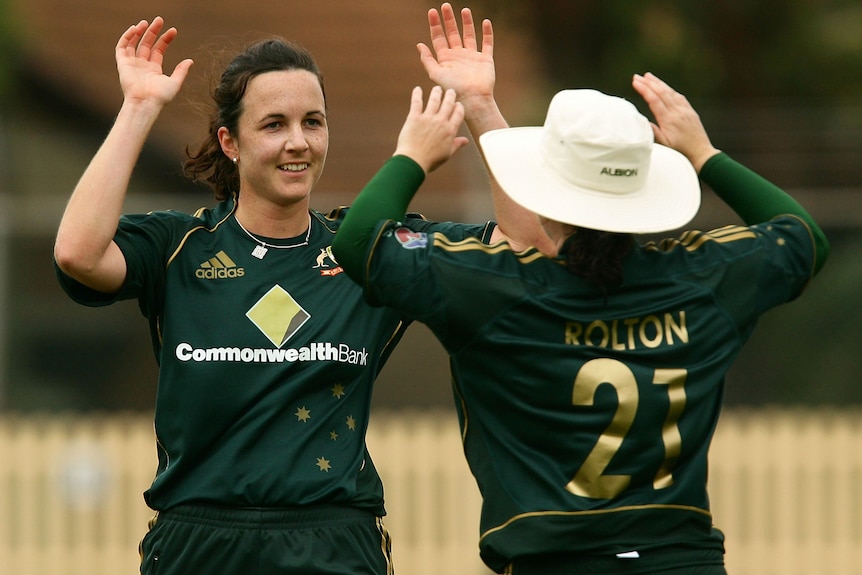 Kirsten Pike and Karen Rolton hold hands before a high ten on the cricket field.