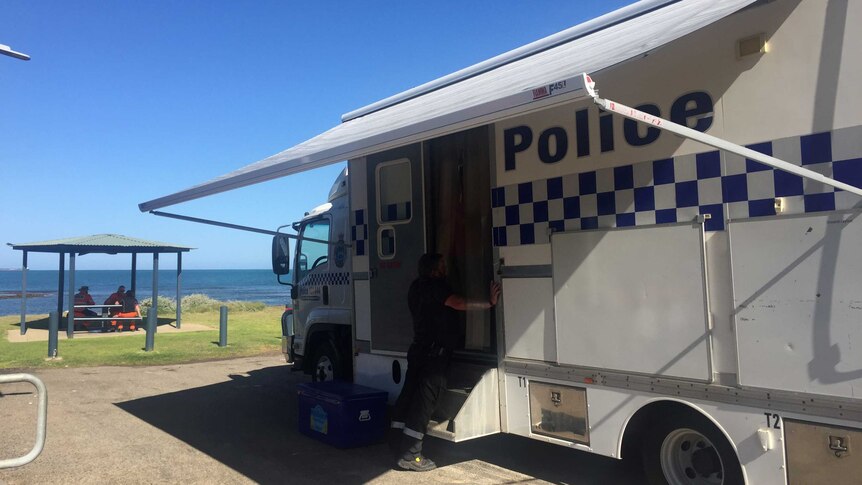 A police truck parked in front of a beach.