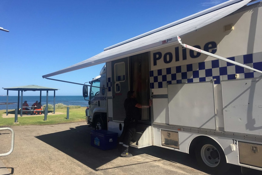 A police truck parked in front of a beach.