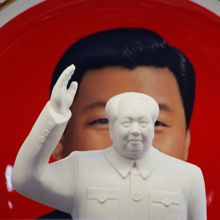 A sculpture of Mao Zedong and a plate featuring Xi Jinping. 