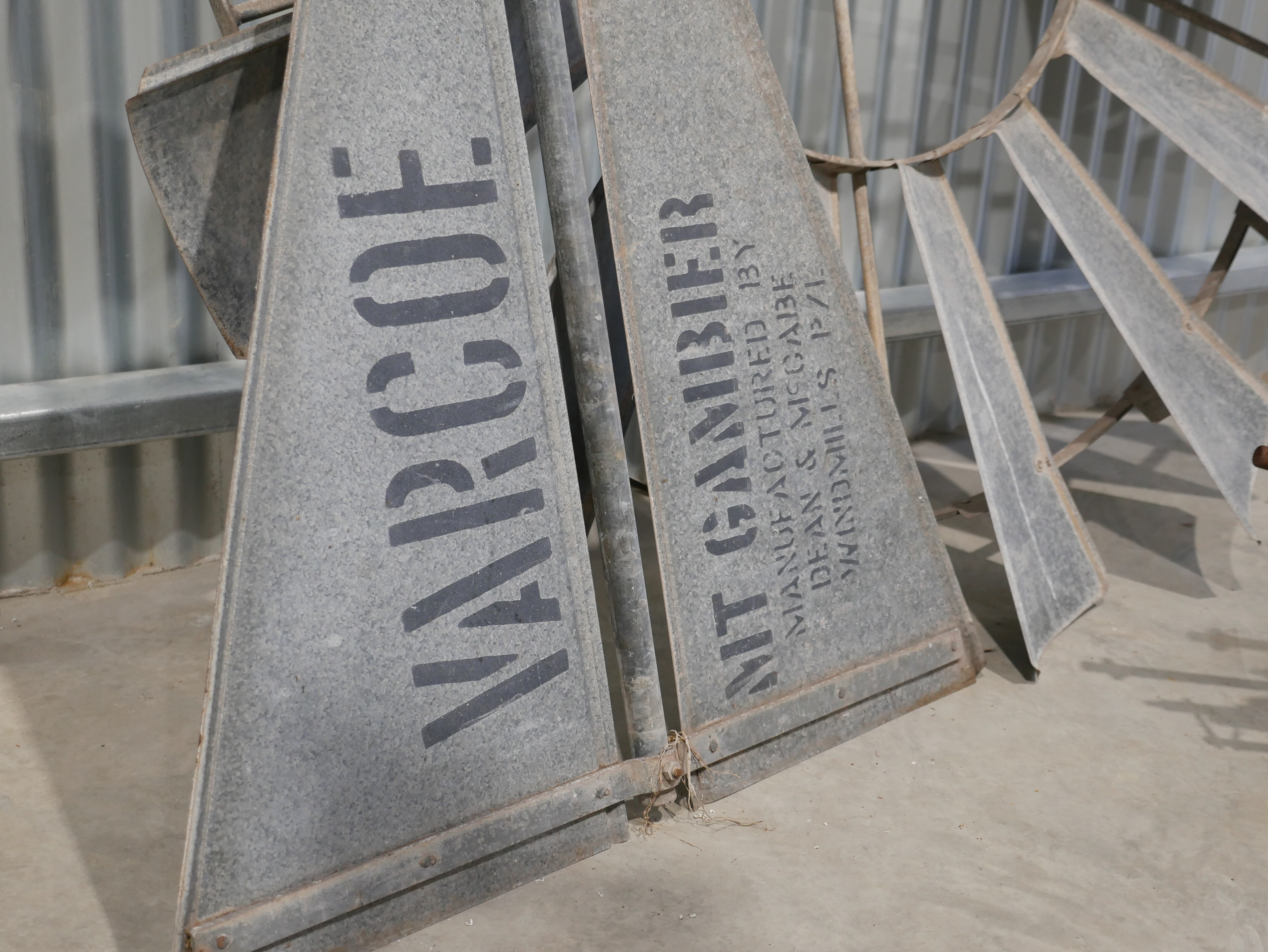 A silver part of a windmill. 