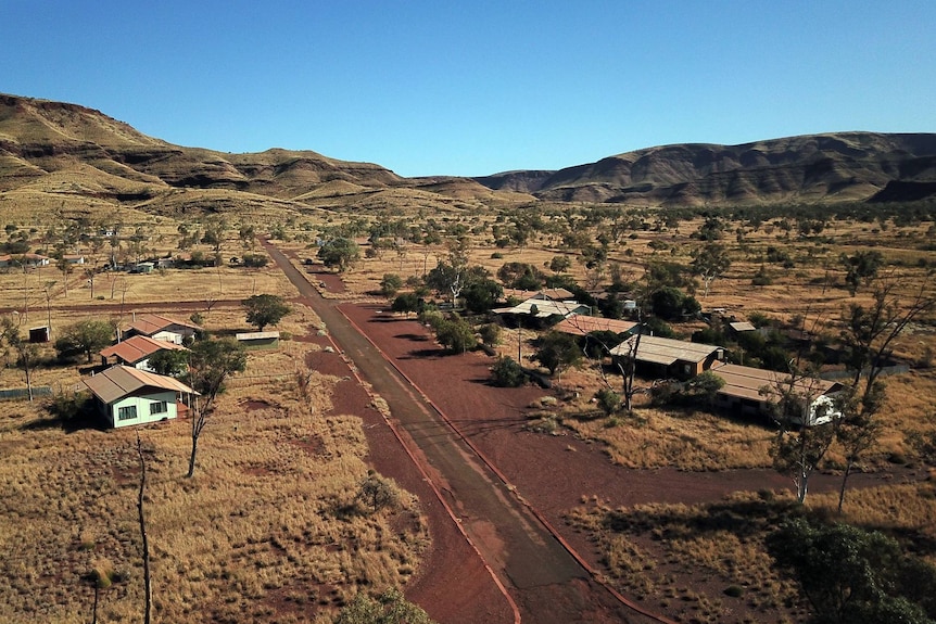 An abandoned town sits at the foot of mountains 