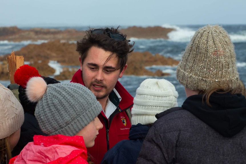 Schoolkids listen to Ranger on the rugged coastline