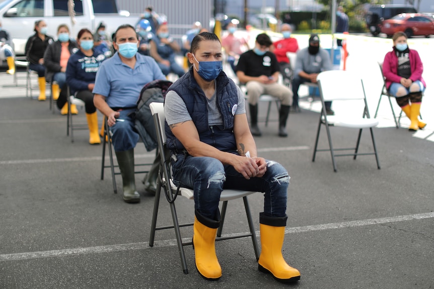 Workers in the US wait after getting a COVID vaccine