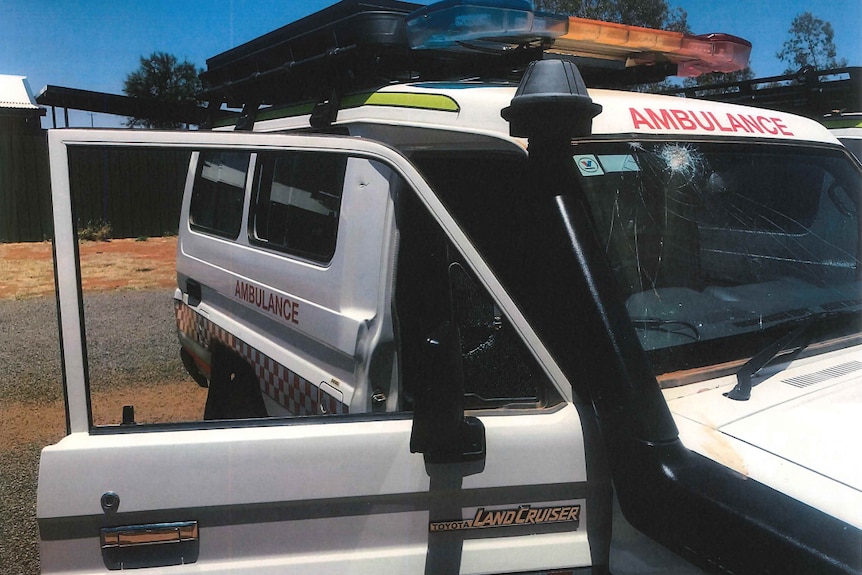 A white ambulance van with a smashed windscreen. 
