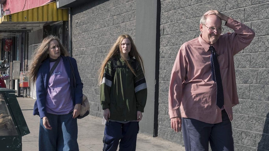 Evan Rachel Wood, Debra Winger and Richard Jenkins walking in street looking worried, dressed poorly.