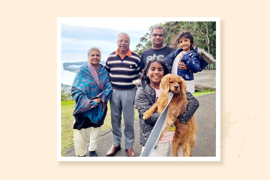 A happy intergenerational family with kids and grandparents, a child holds a dog in foreground