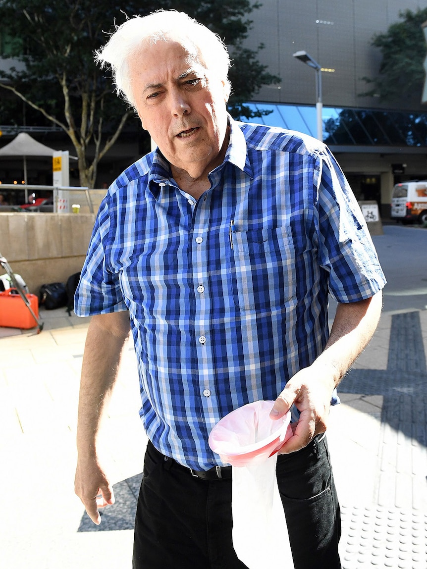 Businessman and former federal MP Clive Palmer arrives holding a sick bag to the Federal Court in Brisbane on May 16, 2017