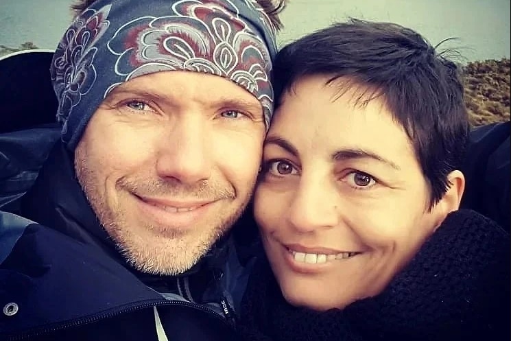 A happy couple embracing with mountains in the background.