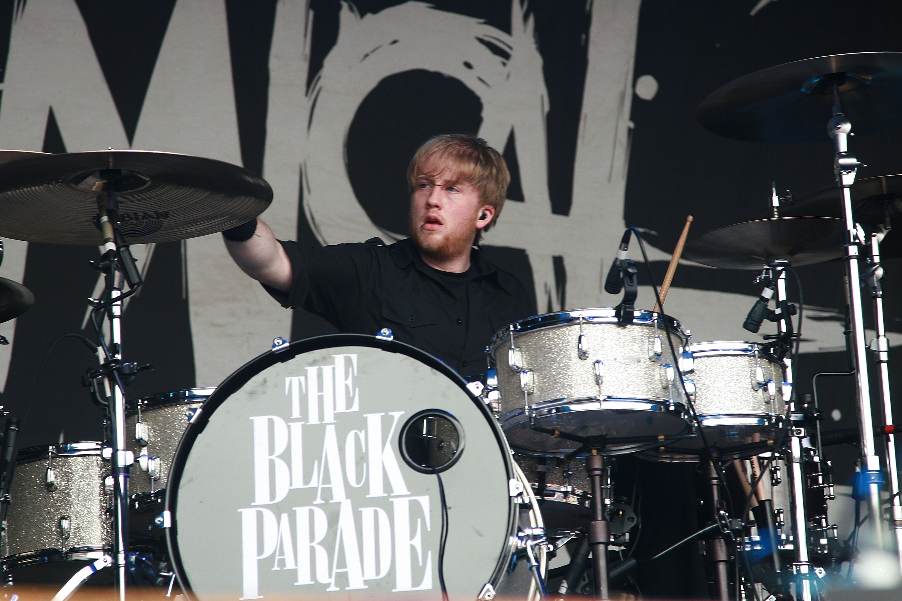 Bob Briar at a drum kit with the black parade written on it. 