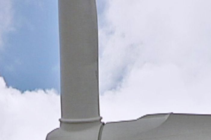 A close up of a wind farm turbine.
