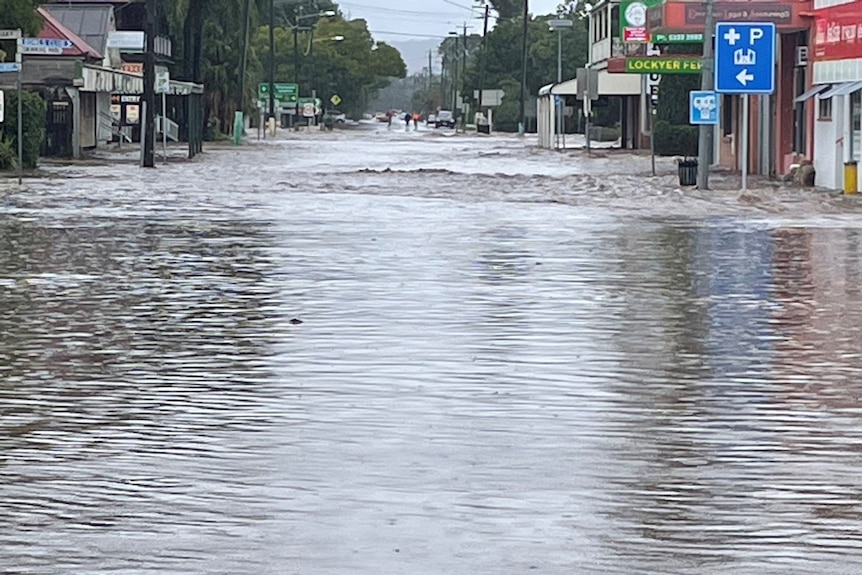 Gushing floodwaters swamp main street and shops of Laidley