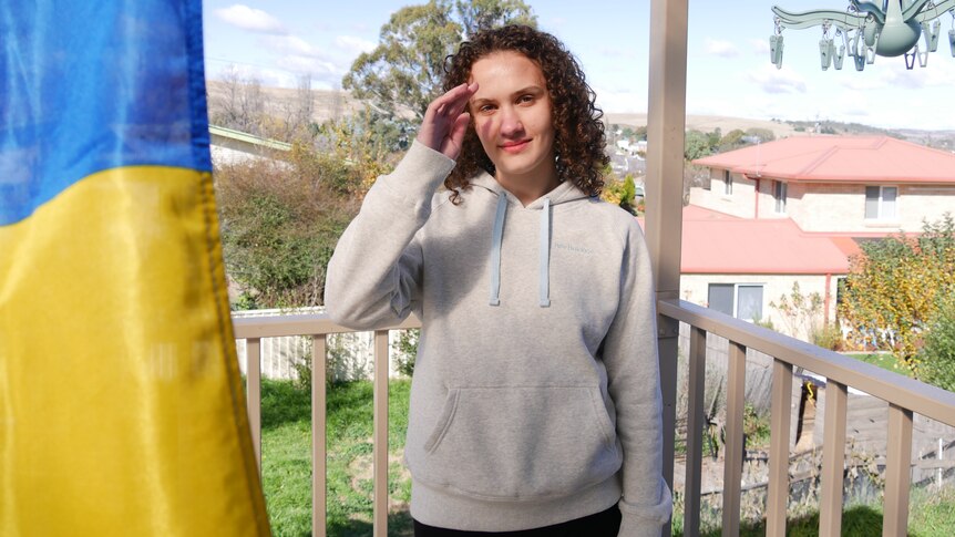 A 19 year old Ukrainian girl on a balcony in Australia with the Ukrainian flag in the foreground