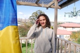 A 19 year old Ukrainian girl on a balcony in Australia with the Ukrainian flag in the foreground