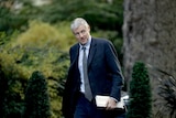 Britain's Minister of State for Environment and International Development Zac Goldsmith walking in front of bushes. 