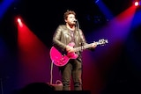 Dan Sultan plays the guitar on stage.