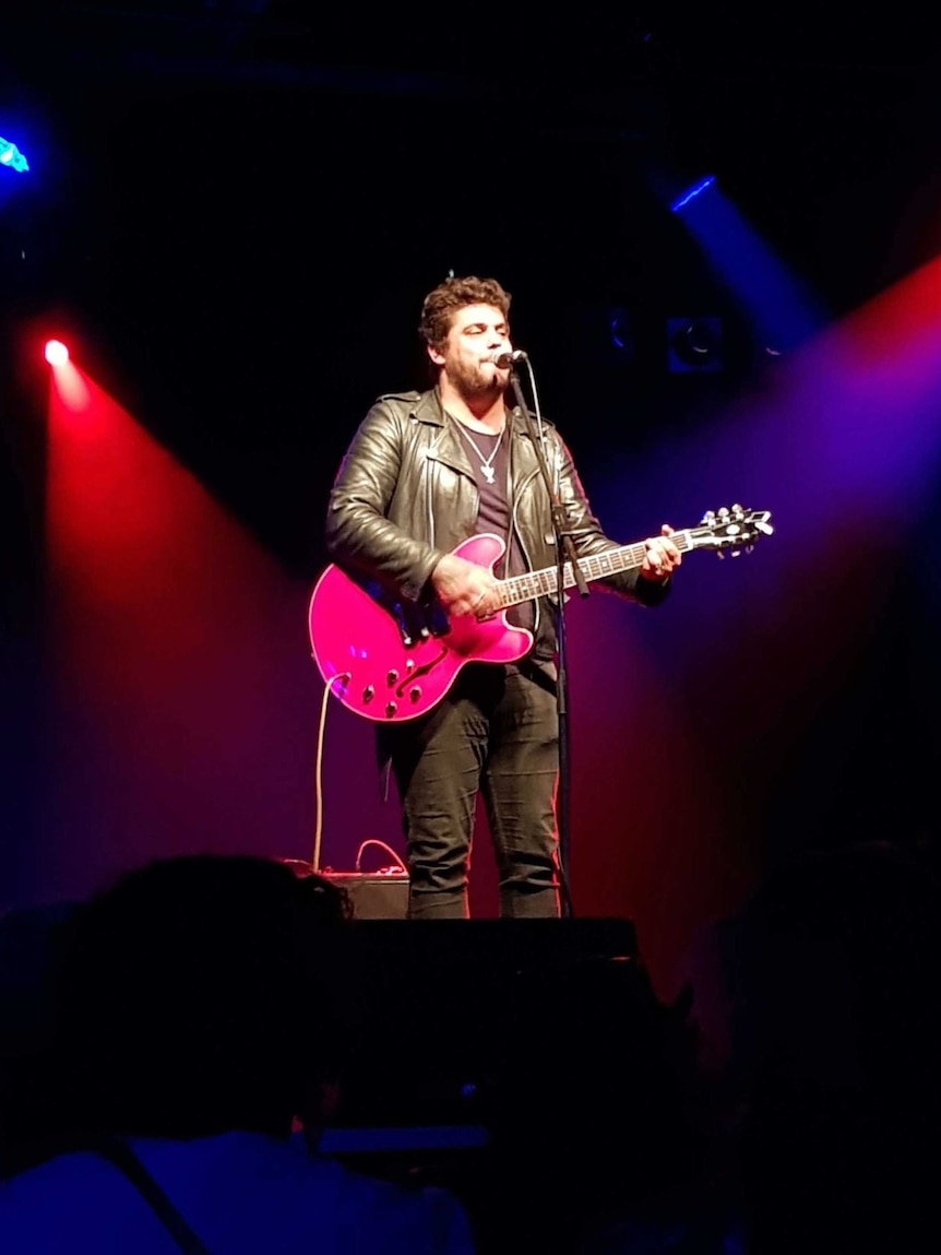 Dan Sultan plays the guitar on stage.