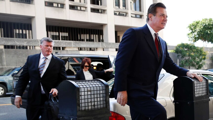 Paul Manafort steps onto the pavement followed by his lawyer Kevin Downing.
