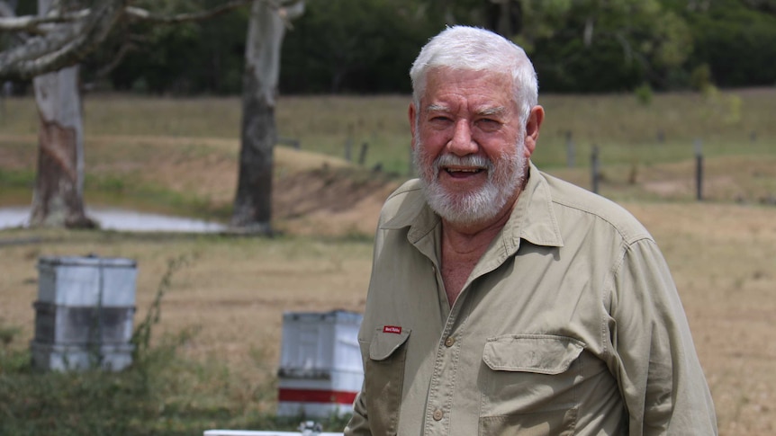 Trevor Weatherhead smiles as he rests his hand on a box in a yard.