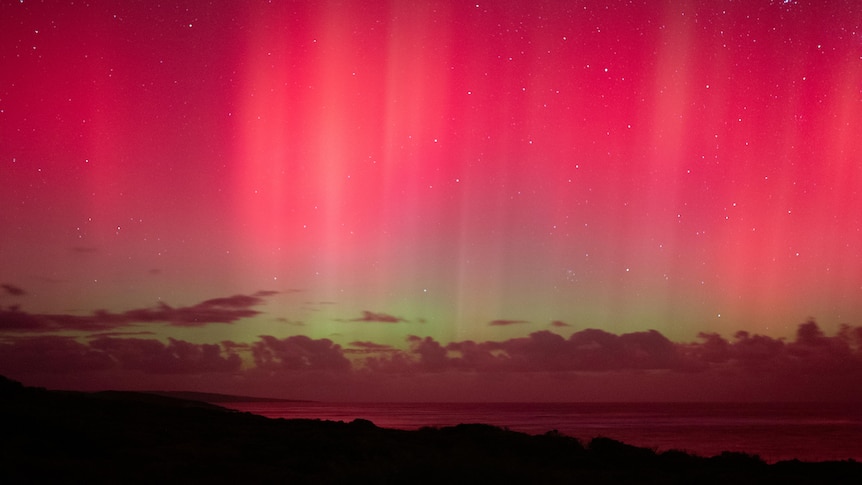 A red and green gradient lights up the night sky.
