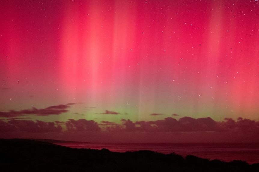 A red and green gradient lights up the night sky.