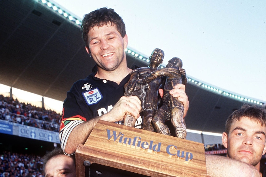 Young man in a Panthers jersey with a trophy 