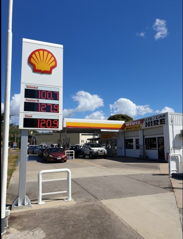 A petrol station with a number of cars at the pumps
