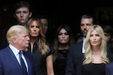 Donald Trump Ivanka, Melania, Barron, and Don Jr stand together looking solemn 