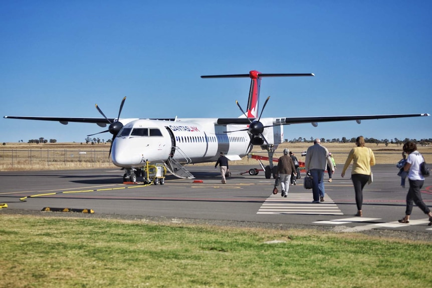 Passengers board a Qantaslink regional plane loading at Roma Airport in south-west Queensland.