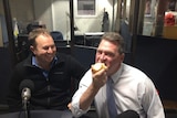 Devonport Mayor Steve Martin taking a big bite into a raw onion in an ABC radio studio in Burnie, north-west Tasmania.
