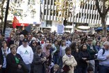 Protesters listen to speeches at a World Refugee Day