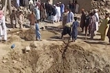 People gather near rubble in the aftermath of Pakistan's military strike on an Iranian village.